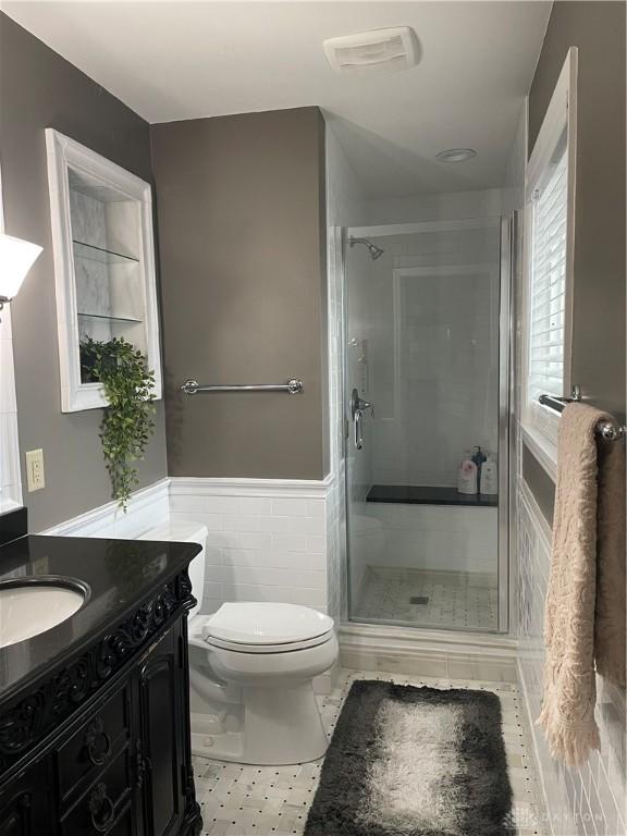 1314 Ridgeview Ave, Dayton, OH 45409 - bathroom with vanity, a stall shower, a wainscoted wall, and tile walls