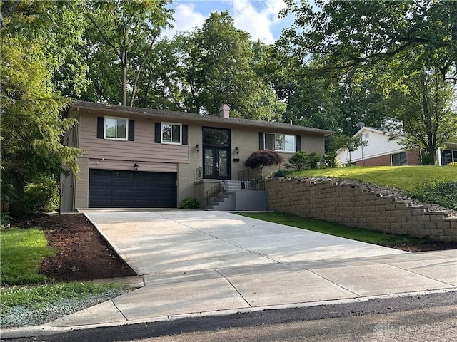 1314 Ridgeview Ave, Dayton, OH 45409 - bi-level home featuring an attached garage, driveway, brick siding, and french doors