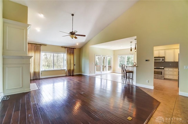 1713 Country Corner Ln, Washington Twp, OH 45458 - unfurnished living room with ceiling fan, high vaulted ceiling, baseboards, and wood finished floors