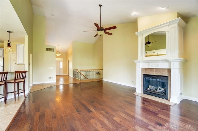 1713 Country Corner Ln, Washington Twp, OH 45458 - unfurnished living room featuring ceiling fan, wood finished floors, high vaulted ceiling, a tile fireplace, and baseboards