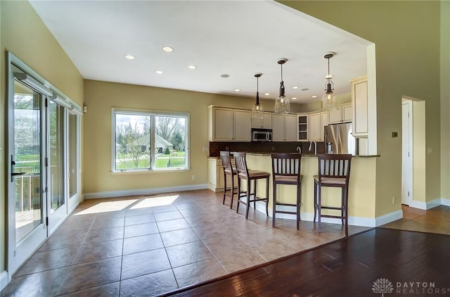 1713 Country Corner Ln, Washington Twp, OH 45458 - kitchen with stainless steel appliances, a breakfast bar area, recessed lighting, hanging light fixtures, and baseboards