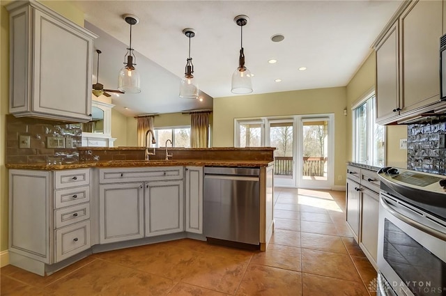 1713 Country Corner Ln, Washington Twp, OH 45458 - kitchen featuring appliances with stainless steel finishes, a sink, light tile patterned floors, decorative backsplash, and vaulted ceiling
