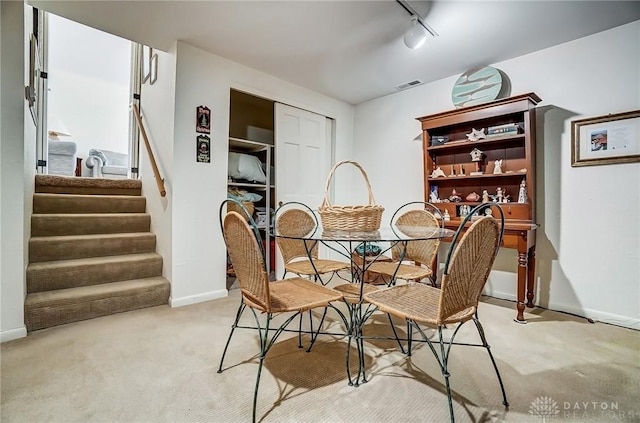 127 W Woodbury Dr, Dayton, OH 45415 - dining room featuring light carpet, baseboards, visible vents, and stairs