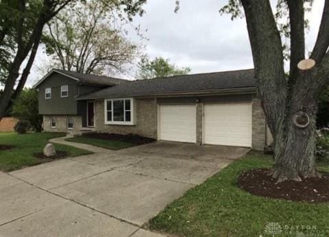 tri-level home featuring a garage and concrete driveway