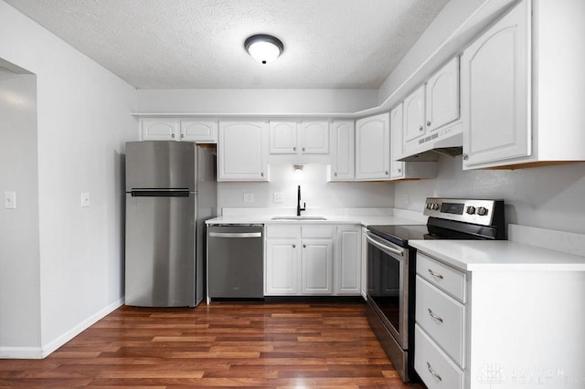 kitchen featuring a textured ceiling, white cabinets, under cabinet range hood, appliances with stainless steel finishes, and a sink