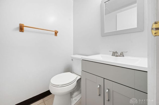 half bathroom featuring toilet, vanity, and tile patterned flooring