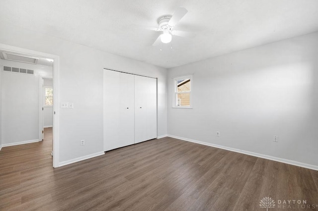 unfurnished bedroom with visible vents, multiple windows, and wood finished floors