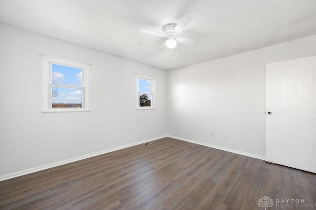 unfurnished room featuring dark wood-style flooring, baseboards, and a ceiling fan