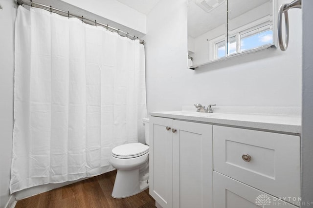 full bath featuring visible vents, a shower with shower curtain, toilet, vanity, and wood finished floors