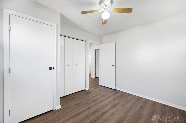 unfurnished bedroom featuring a closet, ceiling fan, baseboards, and wood finished floors