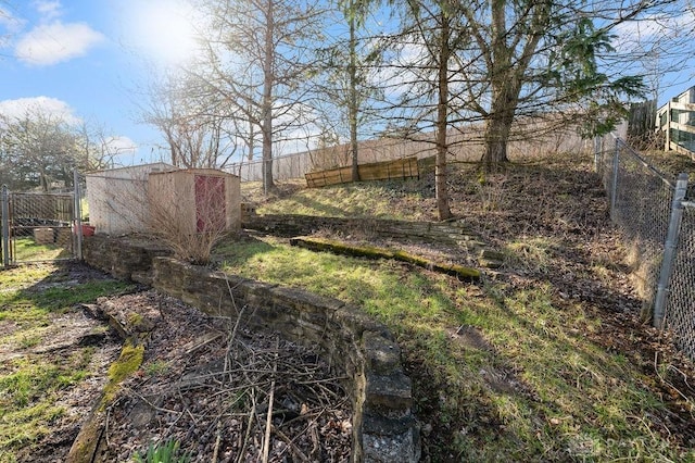 view of yard featuring fence, an outbuilding, and a storage unit