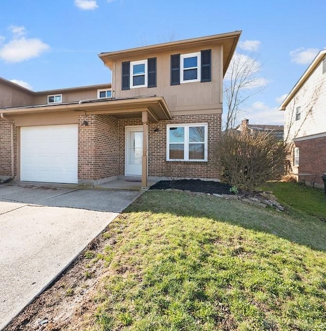 traditional home with brick siding, a front yard, an attached garage, and concrete driveway