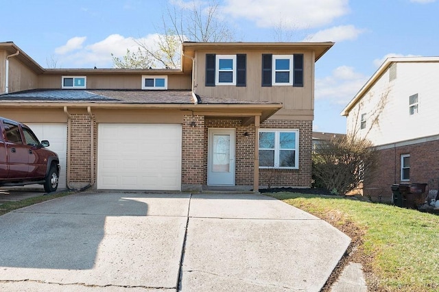 view of front of home with an attached garage, concrete driveway, a front lawn, and brick siding