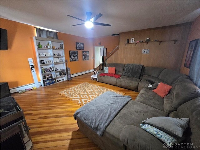 207 E Main St, New Paris, OH 45347 - living area with a baseboard radiator, ceiling fan, wood finished floors, and stairway