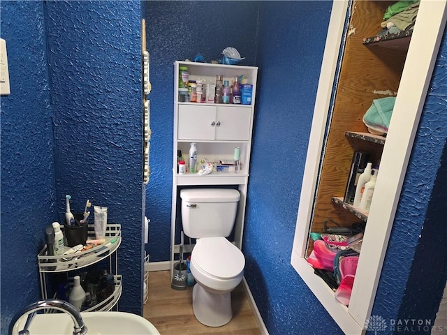 207 E Main St, New Paris, OH 45347 - bathroom with wood finished floors and a textured wall