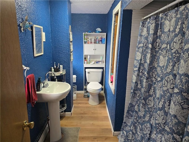207 E Main St, New Paris, OH 45347 - full bathroom featuring a textured wall, wood finished floors, and a shower with shower curtain