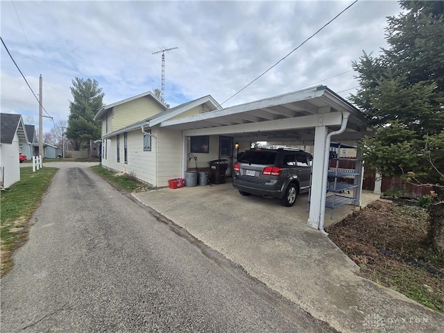 207 E Main St, New Paris, OH 45347 - view of property exterior featuring concrete driveway and a carport