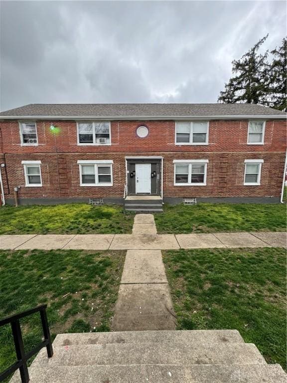 view of front of home with brick siding and a front yard