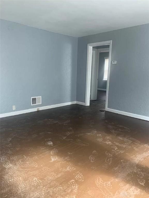 spare room with baseboards and visible vents