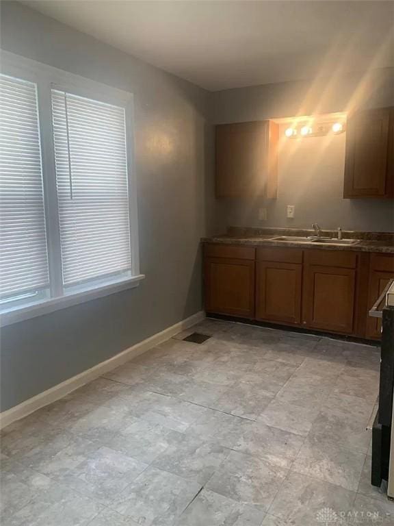 interior space with baseboards, visible vents, a sink, and brown cabinets