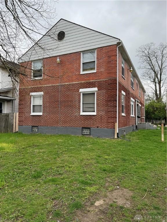 view of home's exterior featuring brick siding and a yard