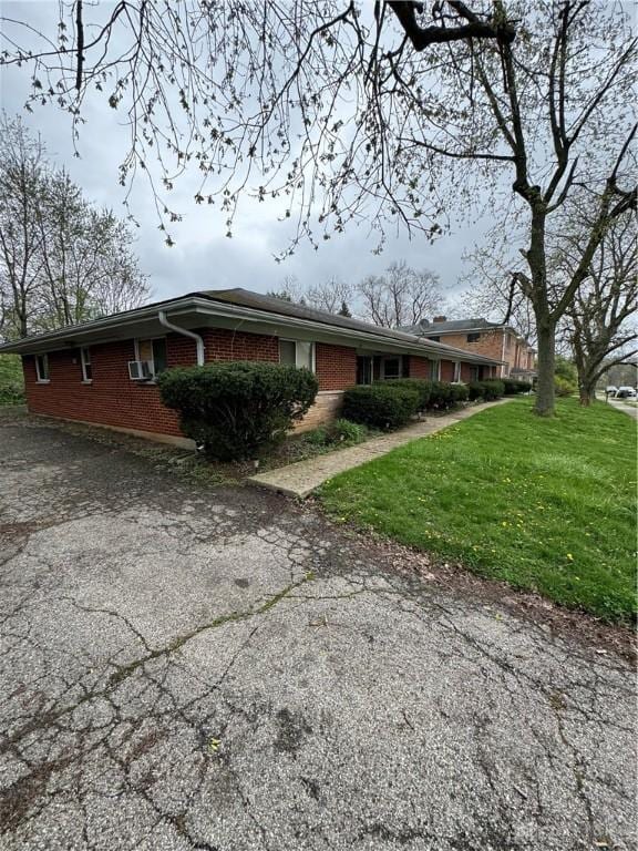 325 Ryburn Ave Unit 319-325, Dayton, OH 45405 - view of side of property with brick siding, asphalt driveway, and a lawn