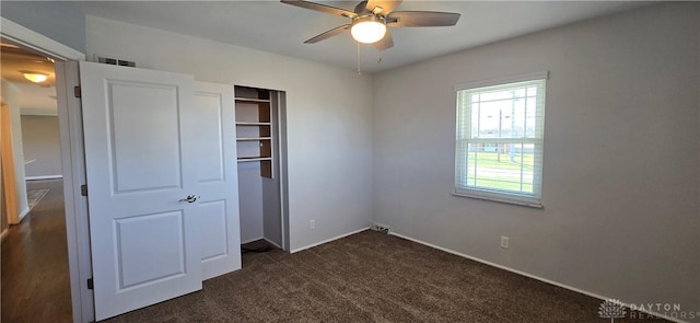 unfurnished bedroom with a closet, ceiling fan, visible vents, and dark colored carpet