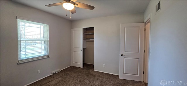 unfurnished bedroom with multiple windows, visible vents, and dark colored carpet