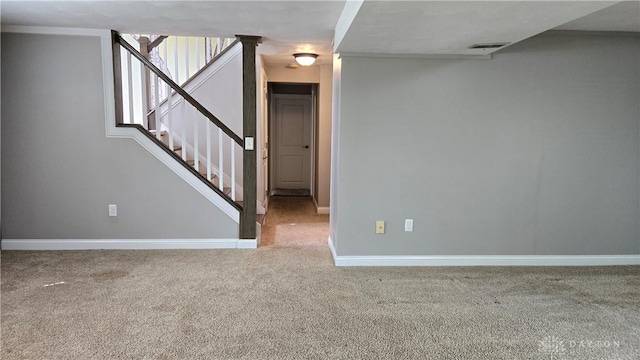 spare room featuring carpet floors, baseboards, stairs, and visible vents