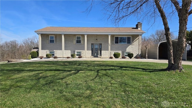 bi-level home featuring a front lawn, a chimney, and brick siding
