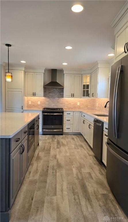 kitchen featuring freestanding refrigerator, wall chimney exhaust hood, dishwashing machine, white cabinets, and electric range