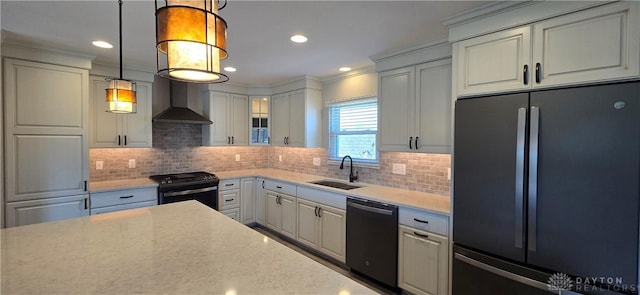 kitchen featuring refrigerator, gas stove, a sink, dishwashing machine, and wall chimney range hood
