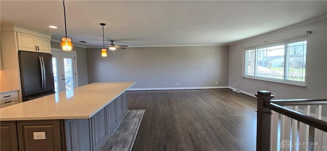 kitchen with freestanding refrigerator, a center island, crown molding, and a wealth of natural light