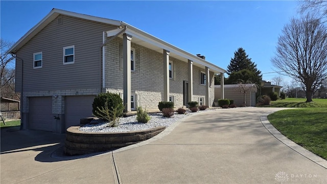 exterior space with driveway, brick siding, and a garage