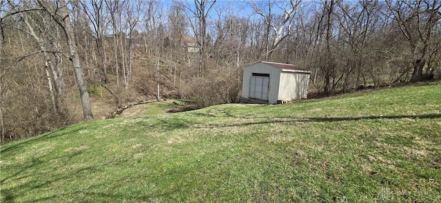 view of yard with an outbuilding, a storage shed, and a forest view
