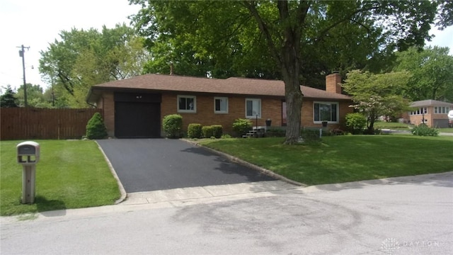 7581 Lockwood St, Dayton, OH 45415 - ranch-style home featuring a garage, a chimney, driveway, and brick siding