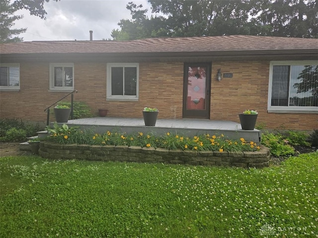 7581 Lockwood St, Dayton, OH 45415 - view of front facade with a front yard and brick siding