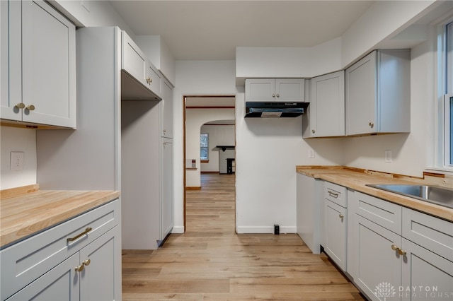 1711 Emerson Ave, Dayton, OH 45406 - kitchen with light wood finished floors, baseboards, wood counters, arched walkways, and under cabinet range hood
