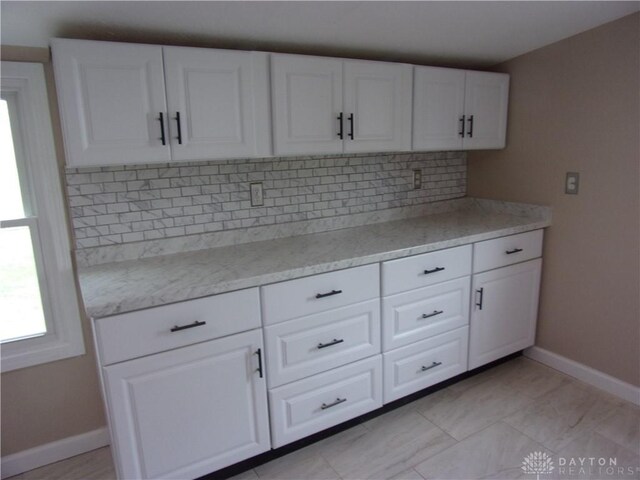 127 New Burlington Rd, Waynesville, OH 45068 - kitchen featuring baseboards, tasteful backsplash, light stone counters, and white cabinets