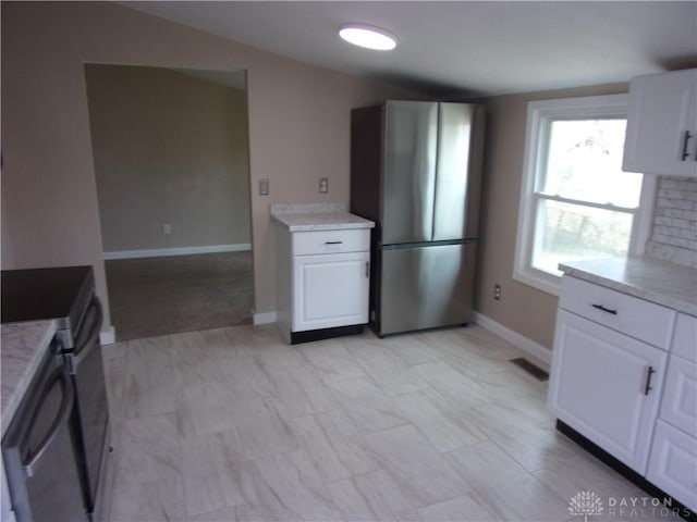 127 New Burlington Rd, Waynesville, OH 45068 - kitchen with white cabinets, visible vents, baseboards, tasteful backsplash, and freestanding refrigerator