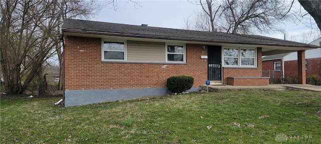 bungalow featuring brick siding, an attached carport, driveway, and a front lawn