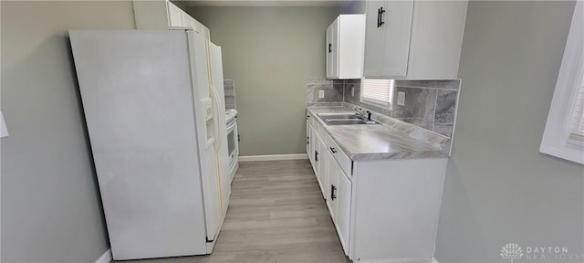kitchen featuring white cabinetry, light countertops, backsplash, a sink, and white fridge with ice dispenser