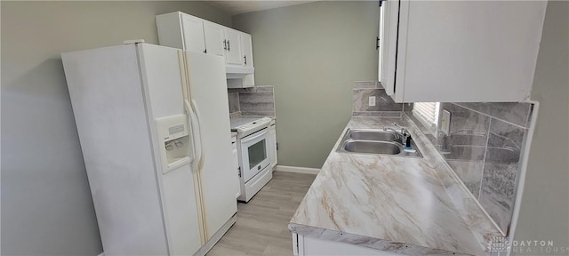 kitchen with white cabinetry, white appliances, backsplash, a sink, and light wood-style floors