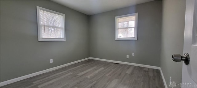 empty room with baseboards and wood finished floors