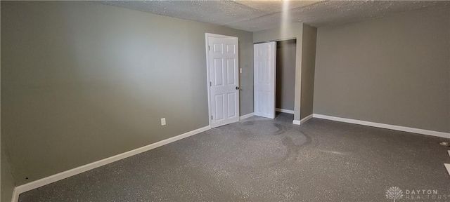 unfurnished bedroom featuring a closet, baseboards, and a textured ceiling