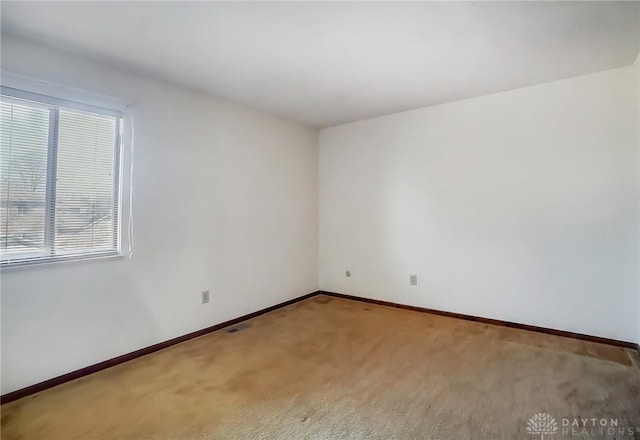 unfurnished room featuring baseboards, carpet flooring, and visible vents