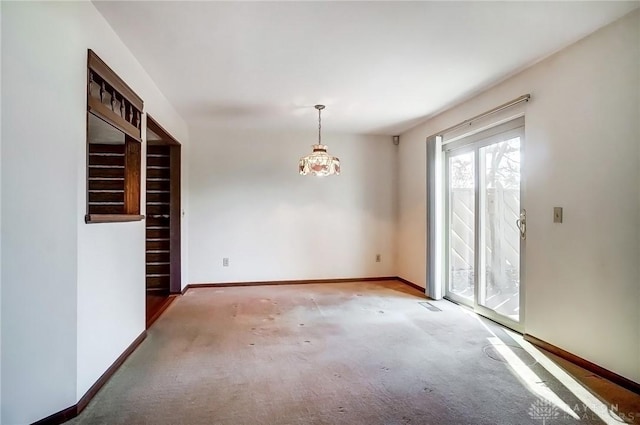 carpeted empty room with baseboards, visible vents, and an inviting chandelier
