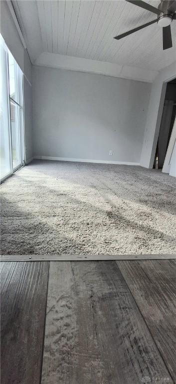 empty room featuring lofted ceiling, wood finished floors, and a ceiling fan