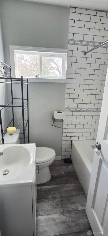 full bathroom featuring wood finished floors, toilet, and vanity