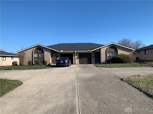 view of front of home featuring brick siding, driveway, and a garage